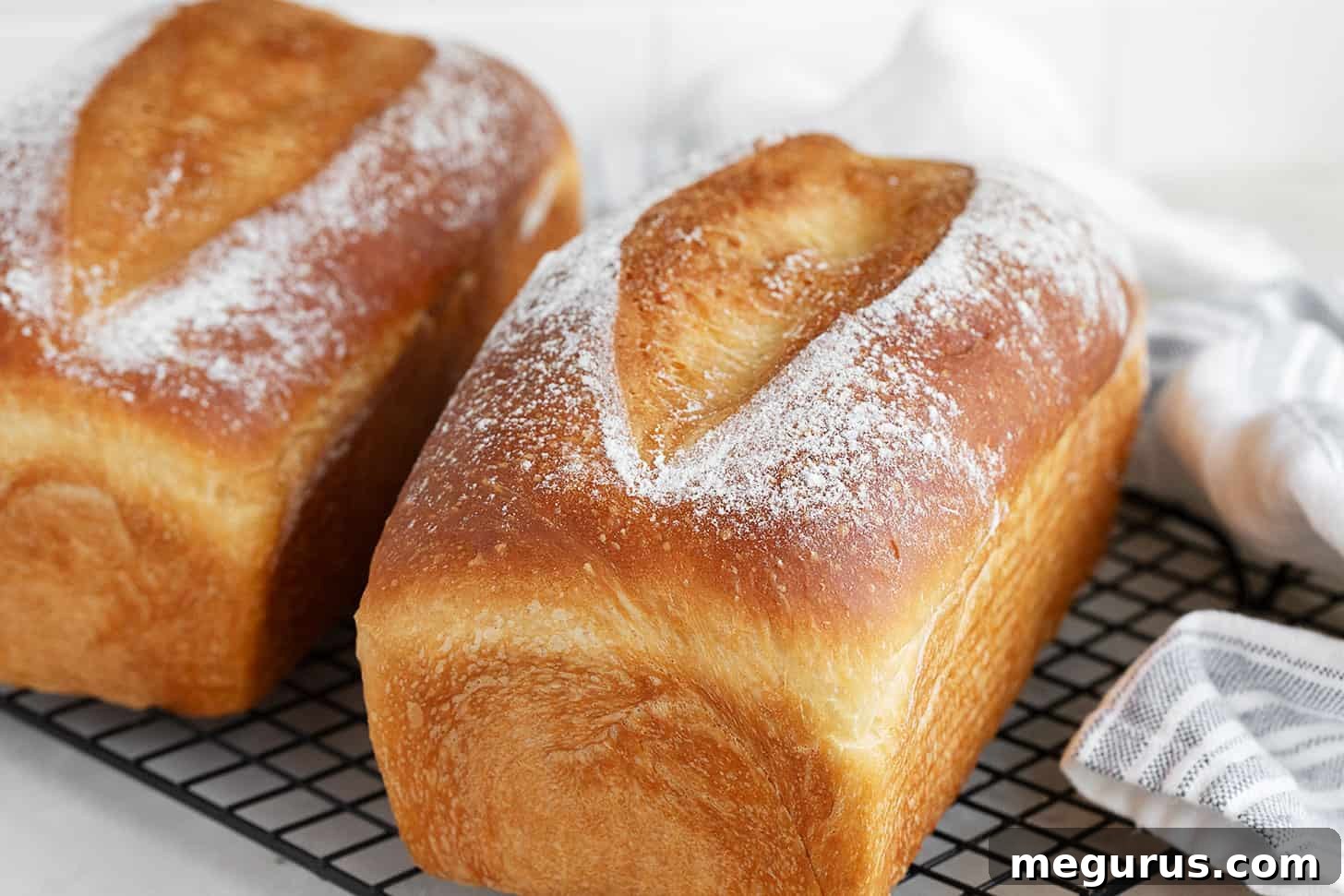Golden brown overnight sandwich bread cooling on a wire rack, showcasing its perfect crust and shape.