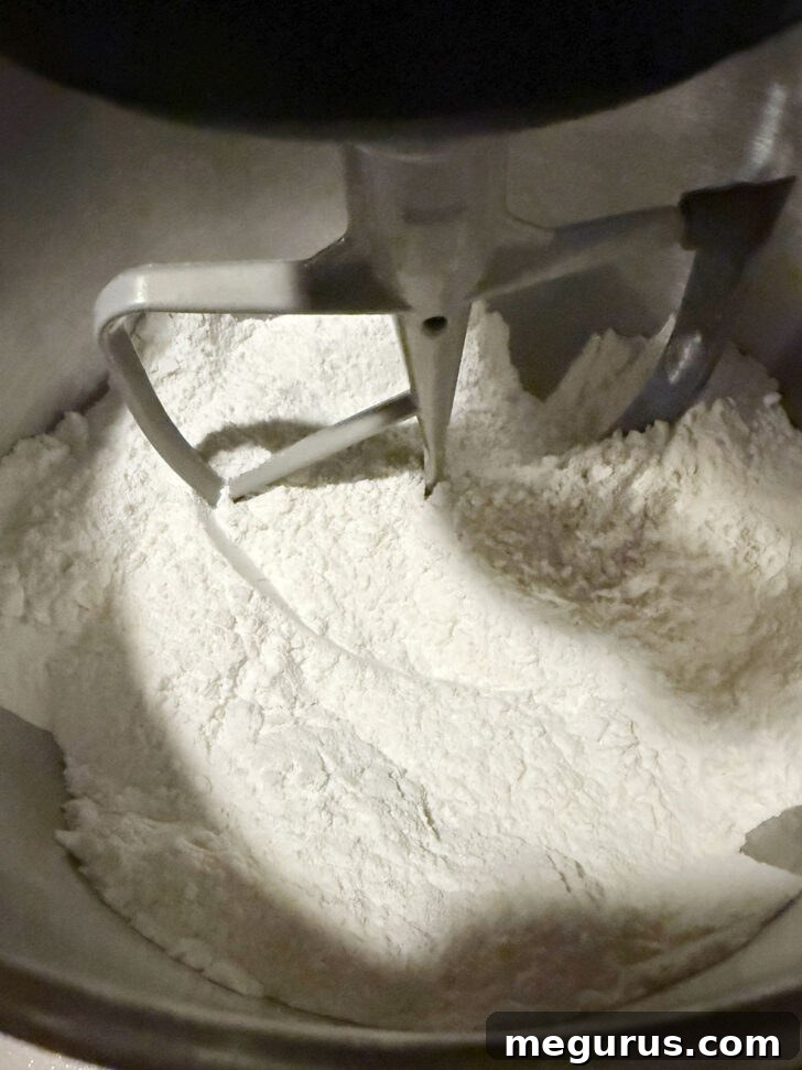 Flour mixture in bowl of stand mixer with paddle attachment.