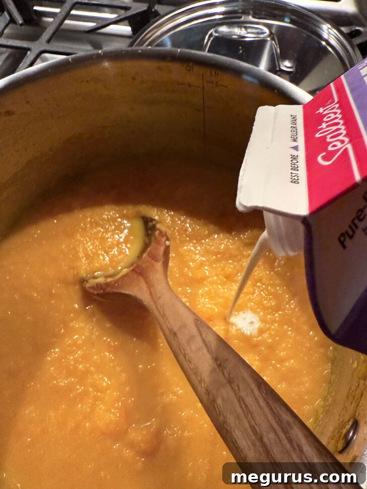 Adding a splash of cream to the soup.