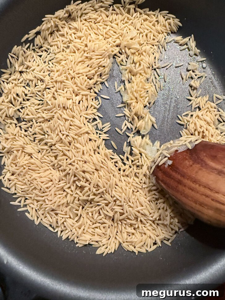Cooking orzo with the butter and onion in the skillet.