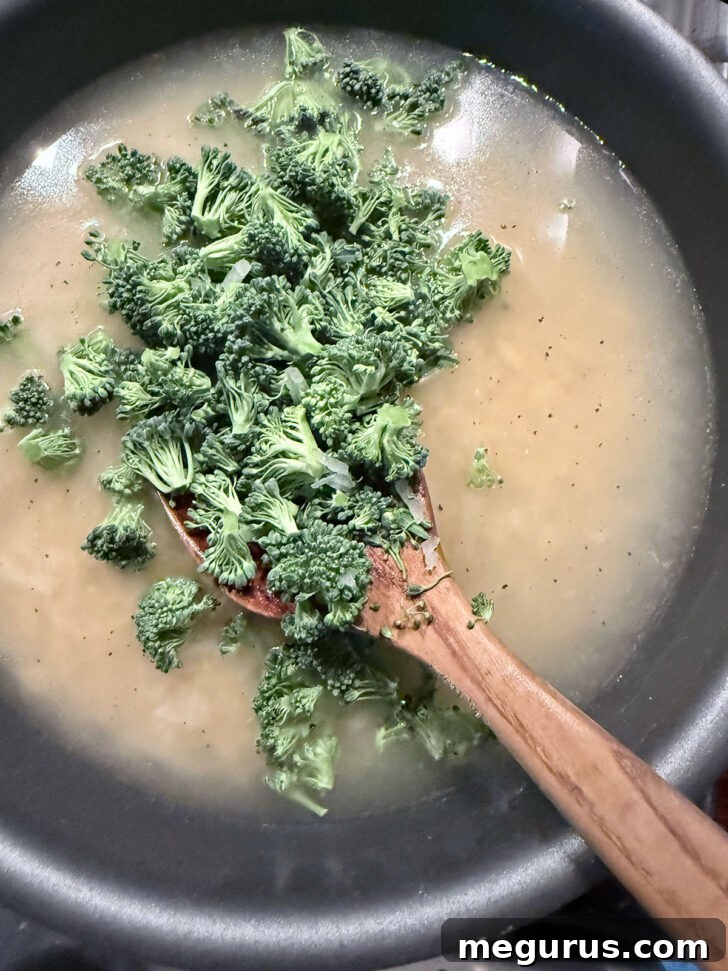 Adding broccoli florets to the skillet.