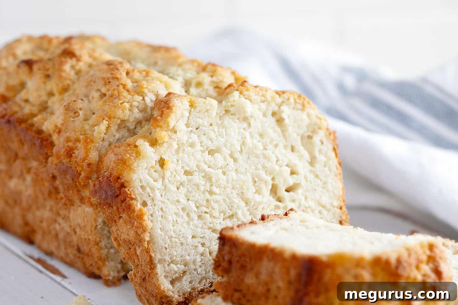 Sliced Honey Butter Beer Bread on a cutting board, ready to be served.