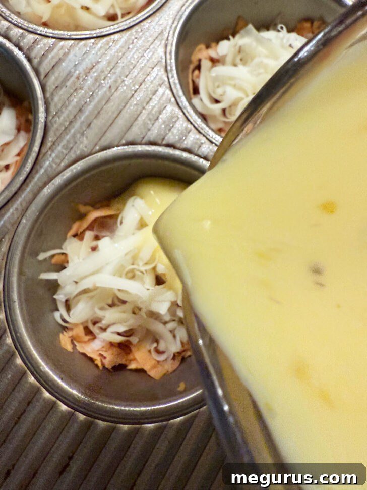 Pouring the egg custard mixture into the muffin cups, half full.