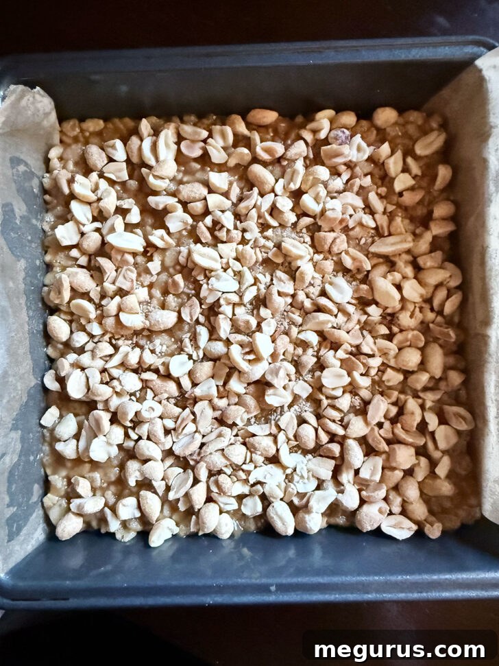 Chopped peanuts scattered over the rice krispie layer.