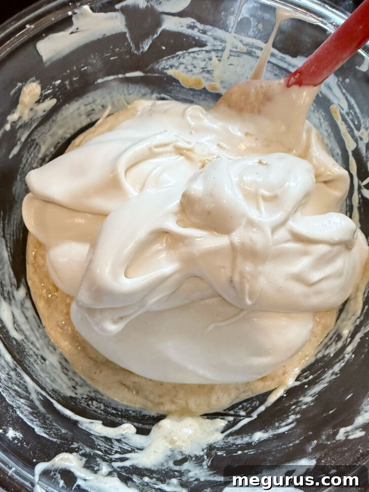 Adding the rest of the whipped egg whites to the cake batter.