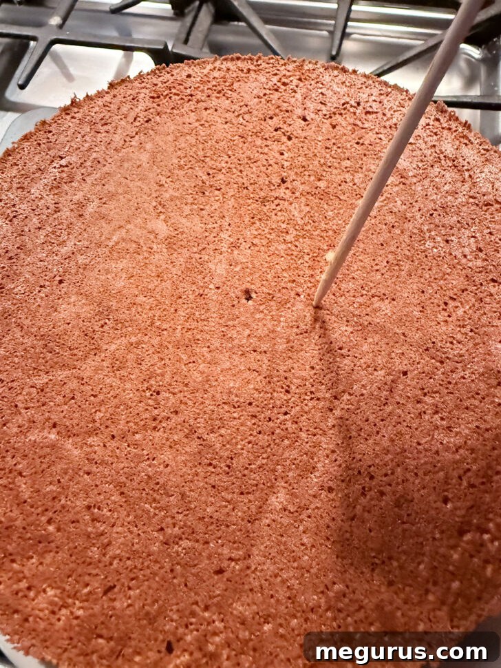 Poking holes in the top of the cake with a skewer for milk absorption.