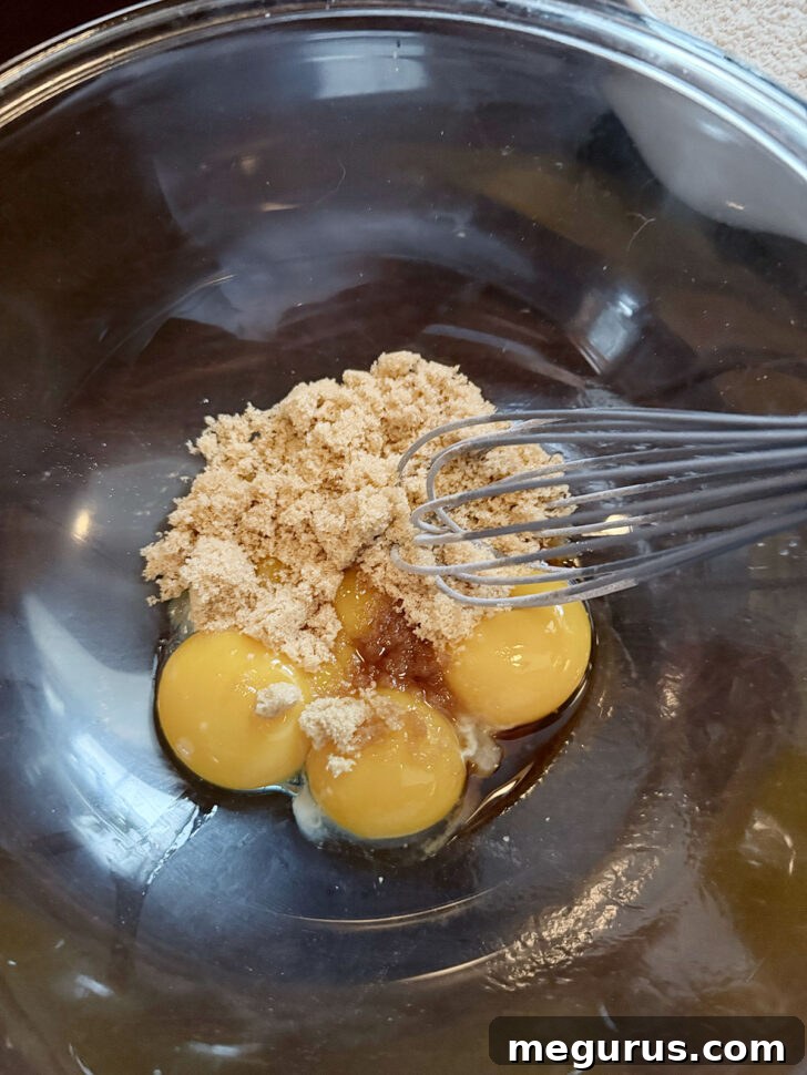 Eggs, brown sugar and vanilla in mixing bowl, ready to be whisked.