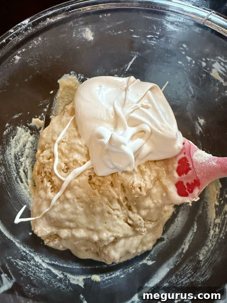 Adding some of the whipped egg white mixture to the batter.