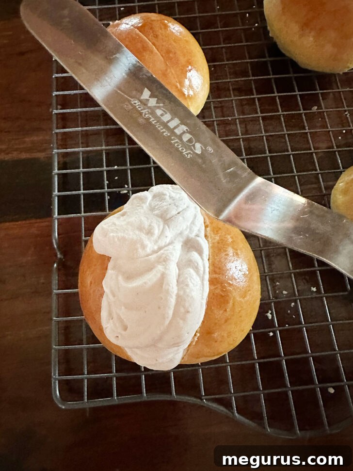 Maritozzi over-filled with whipped cream, demonstrating the generous filling technique.