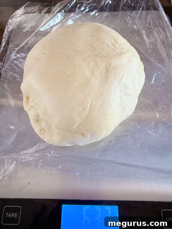 Weighing out the dough on a scale to ensure even portions.