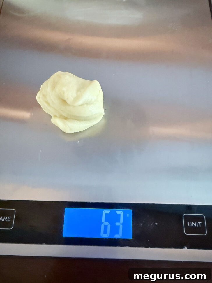 Weighing individual dough portions on a scale for consistency.