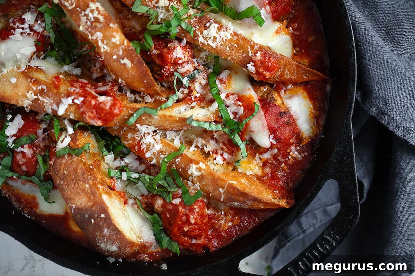 Hearty meatball sub casserole bubbling in a cast iron skillet, ready to serve.