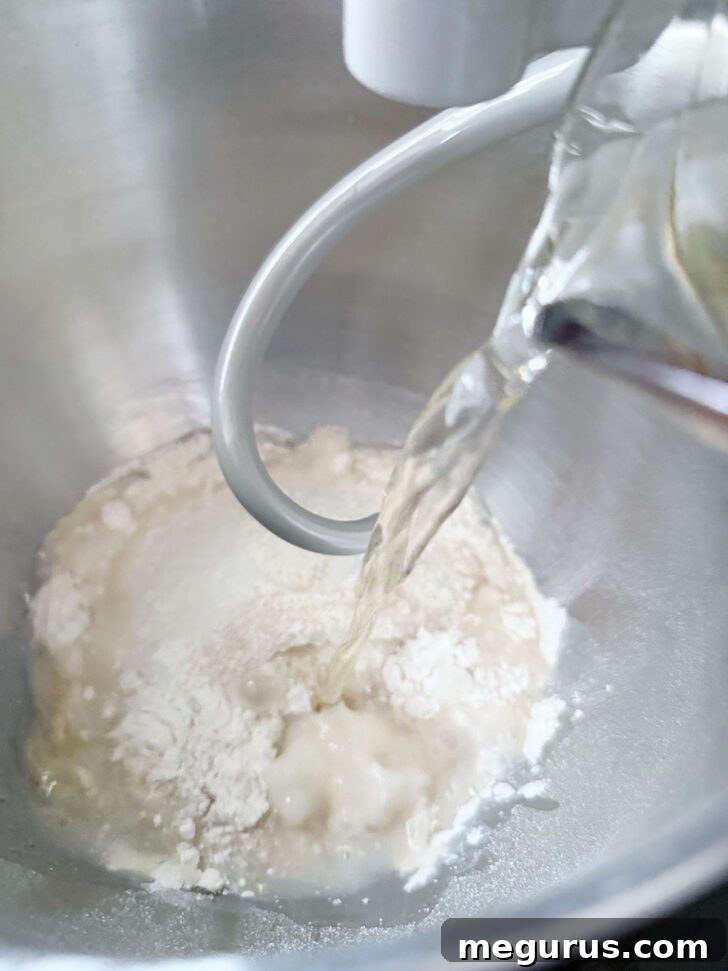 Mixing the focaccia dough in a stand mixer bowl, showing the initial sticky consistency.
