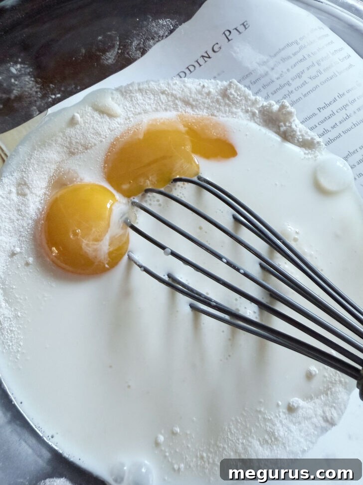 Adding egg yolks to the bowl for the batter.