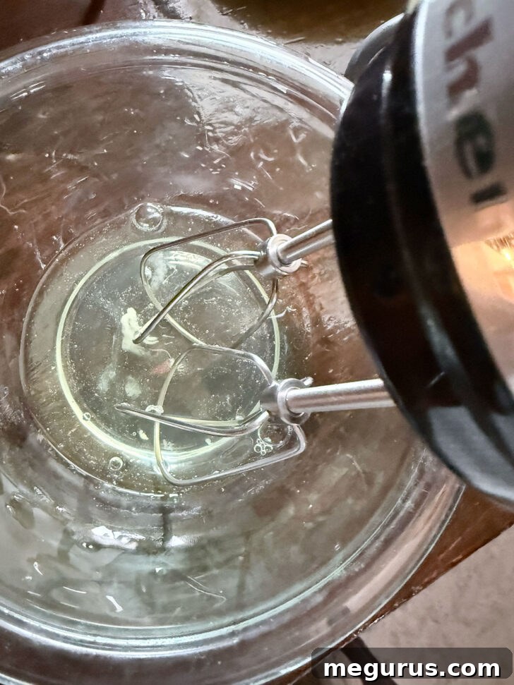 Egg whites in a mixing bowl, ready for beating with an electric beater.