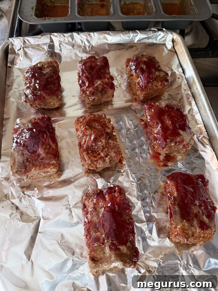 Cooked mini meatloaves carefully removed from their pans and placed on a foil-lined baking sheet for a final crisping.