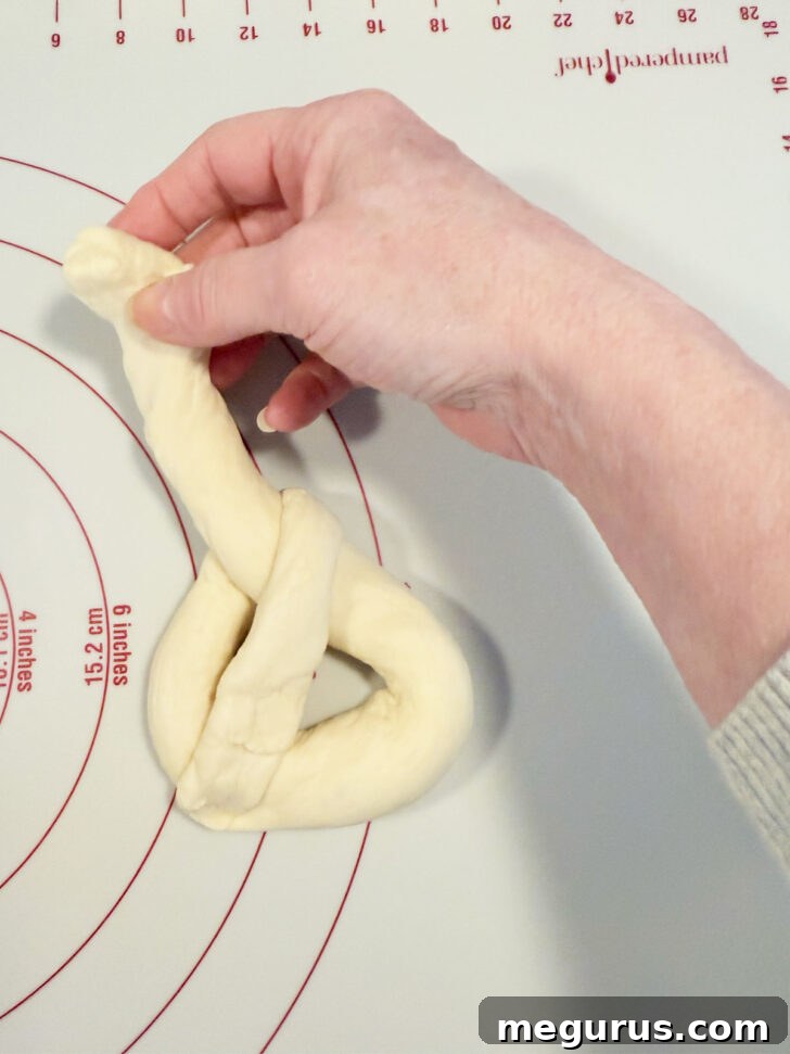 Folding down the right end of the rope and pressing it into the bottom.
