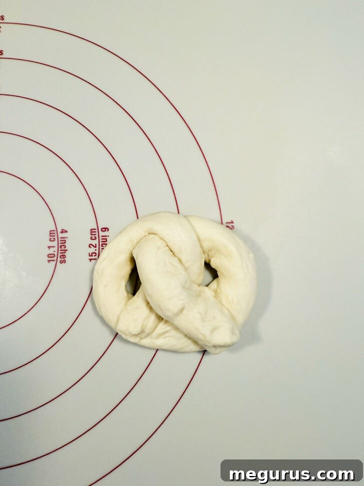 Finished pretzel shape on work surface, with ends neatly tucked.