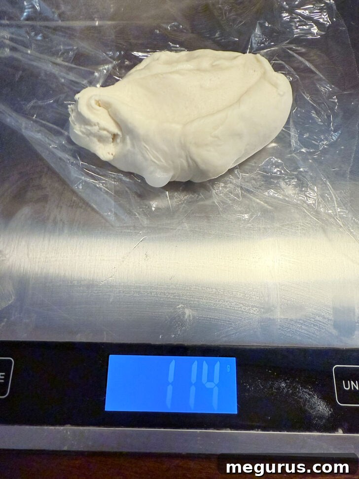 Dough being weighed out into equal pieces on a kitchen scale.