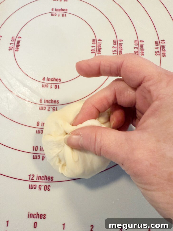 Forming the dough pieces into smooth, round balls.