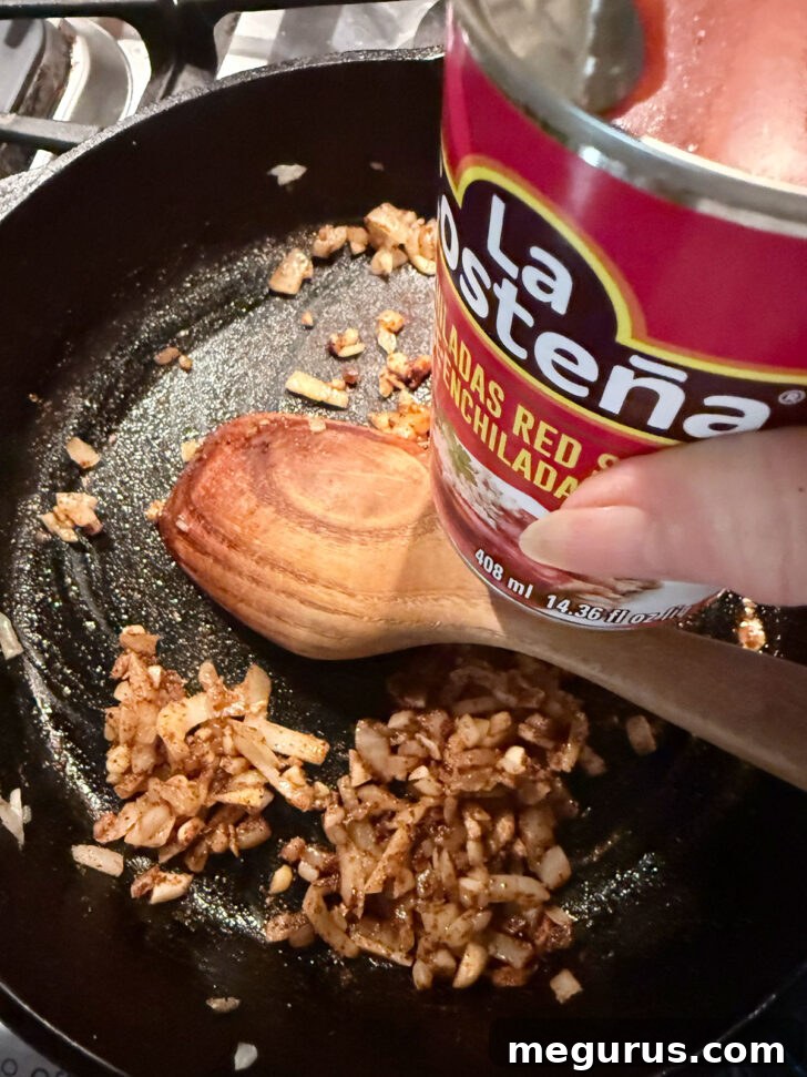 Adding the enchilada sauce to the skillet.