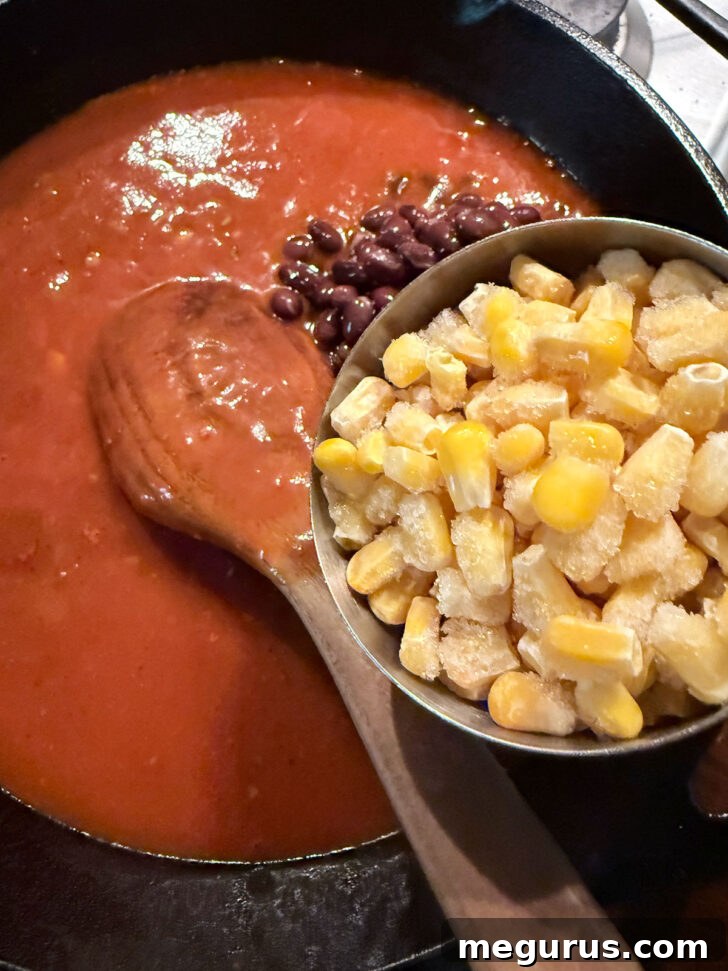 Adding the black beans and corn to the skillet.