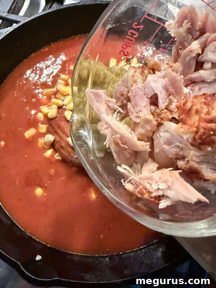 Adding the cooked chicken to the skillet.