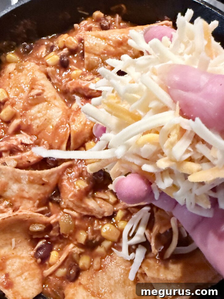 Topping with shredded cheese before baking.
