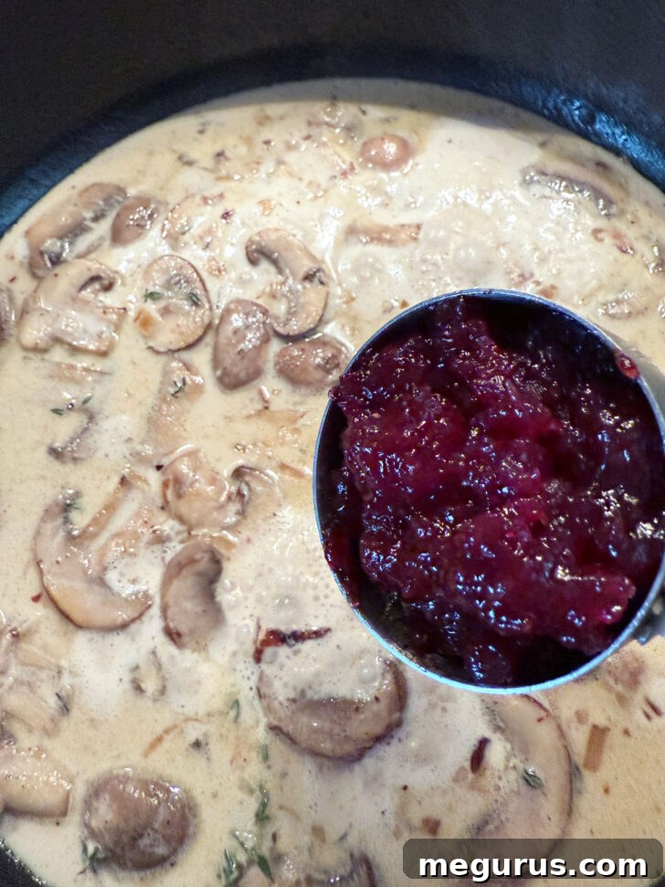 Adding the lingonberry jam to the mushroom sauce.
