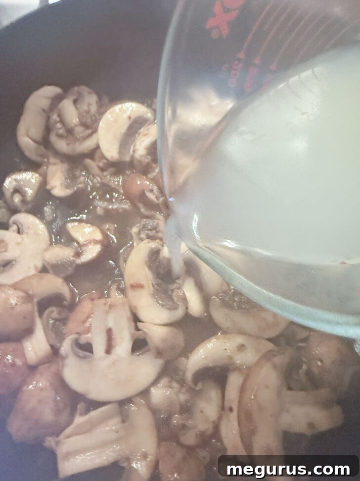 Adding the chicken broth to the skillet.