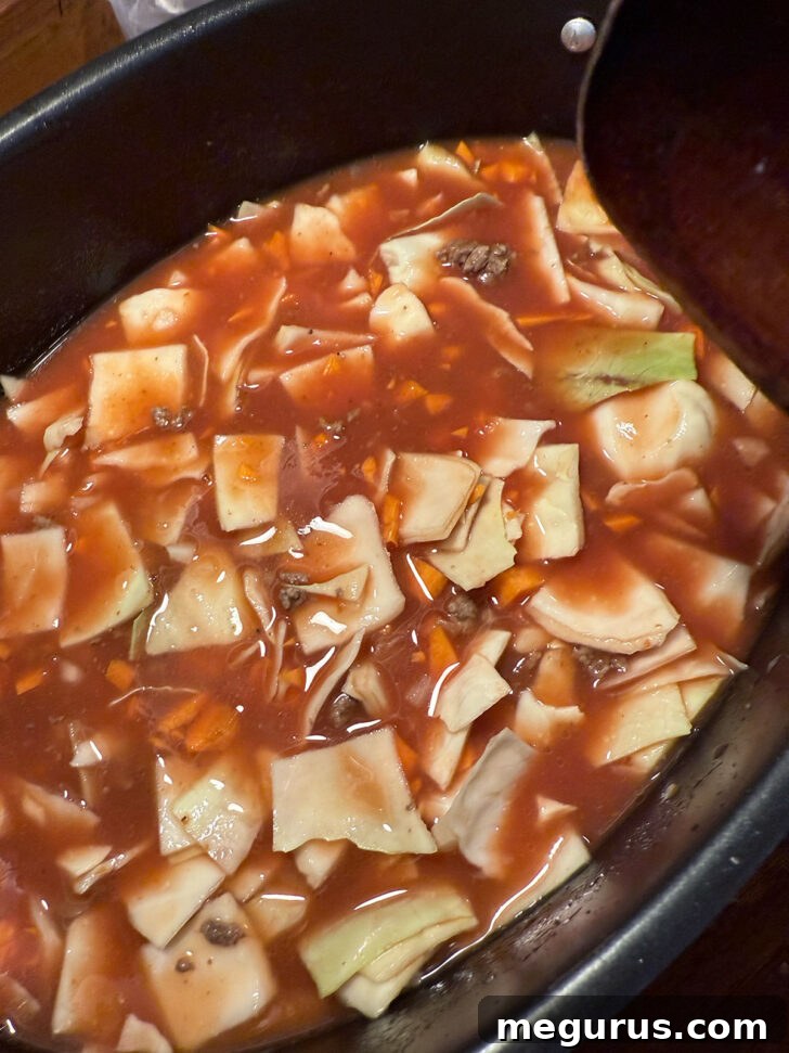 Cabbage roll soup ingredients in the slow cooker before cooking starts, ready to be covered.