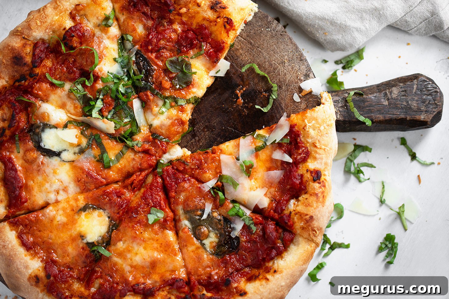 Vodka sauce pizza sliced on cutting board, showcasing its rich toppings and golden crust.