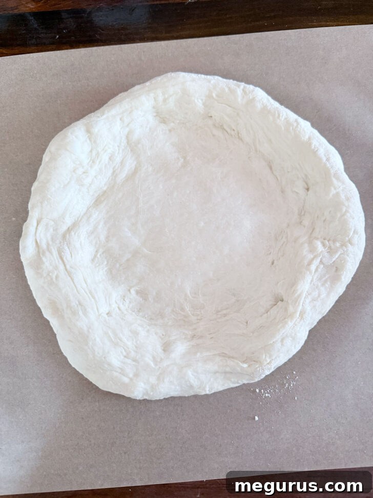 Pressing the dough into an 8-inch circle.