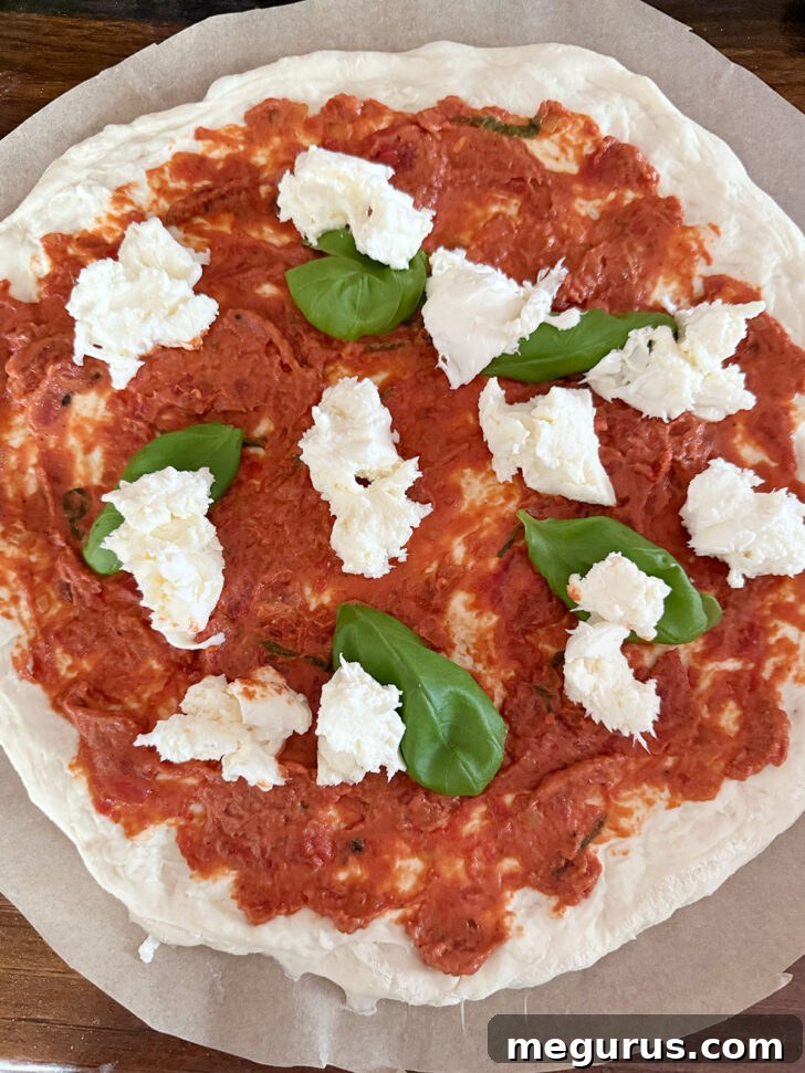 Vodka sauce pizza topped with fresh mozzarella and fresh basil leaves.