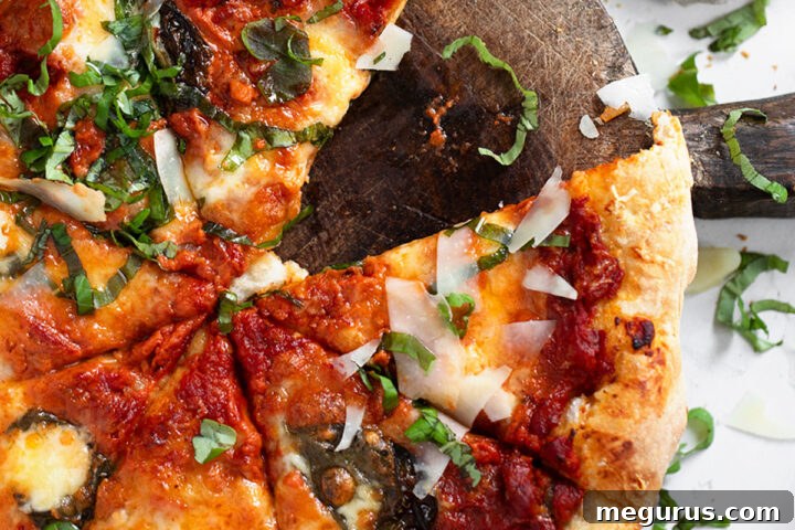 Vodka sauce pizza sliced on cutting board.