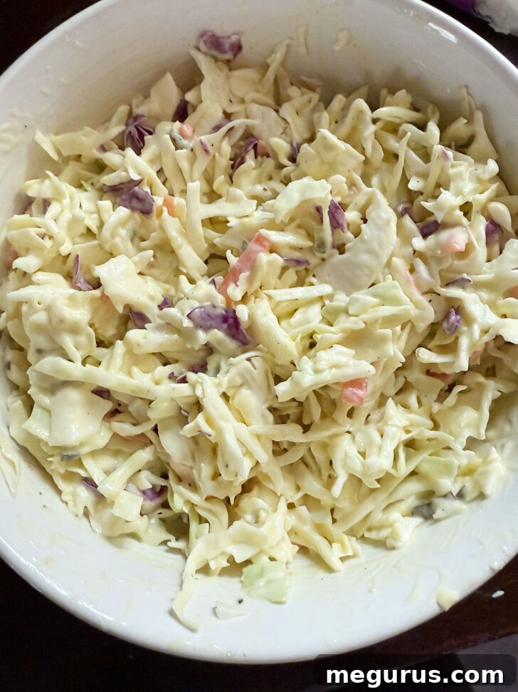 Cabbage mix thoroughly coated with the dill pickle dressing after mixing.