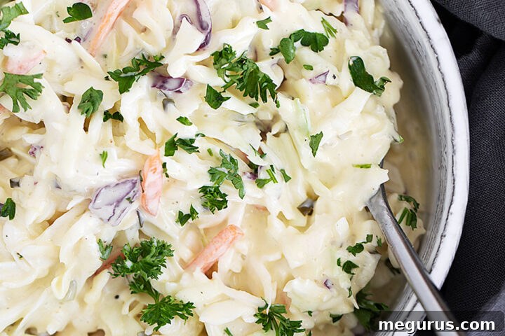 Dill pickle coleslaw in serving dish with spoon.