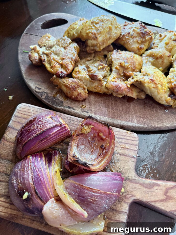 Cooked chicken and onion on cutting boards after roasting.