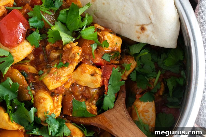 Chicken jalfrezi in copper serving bowl with naan bread, beautifully plated for an authentic Indian meal.