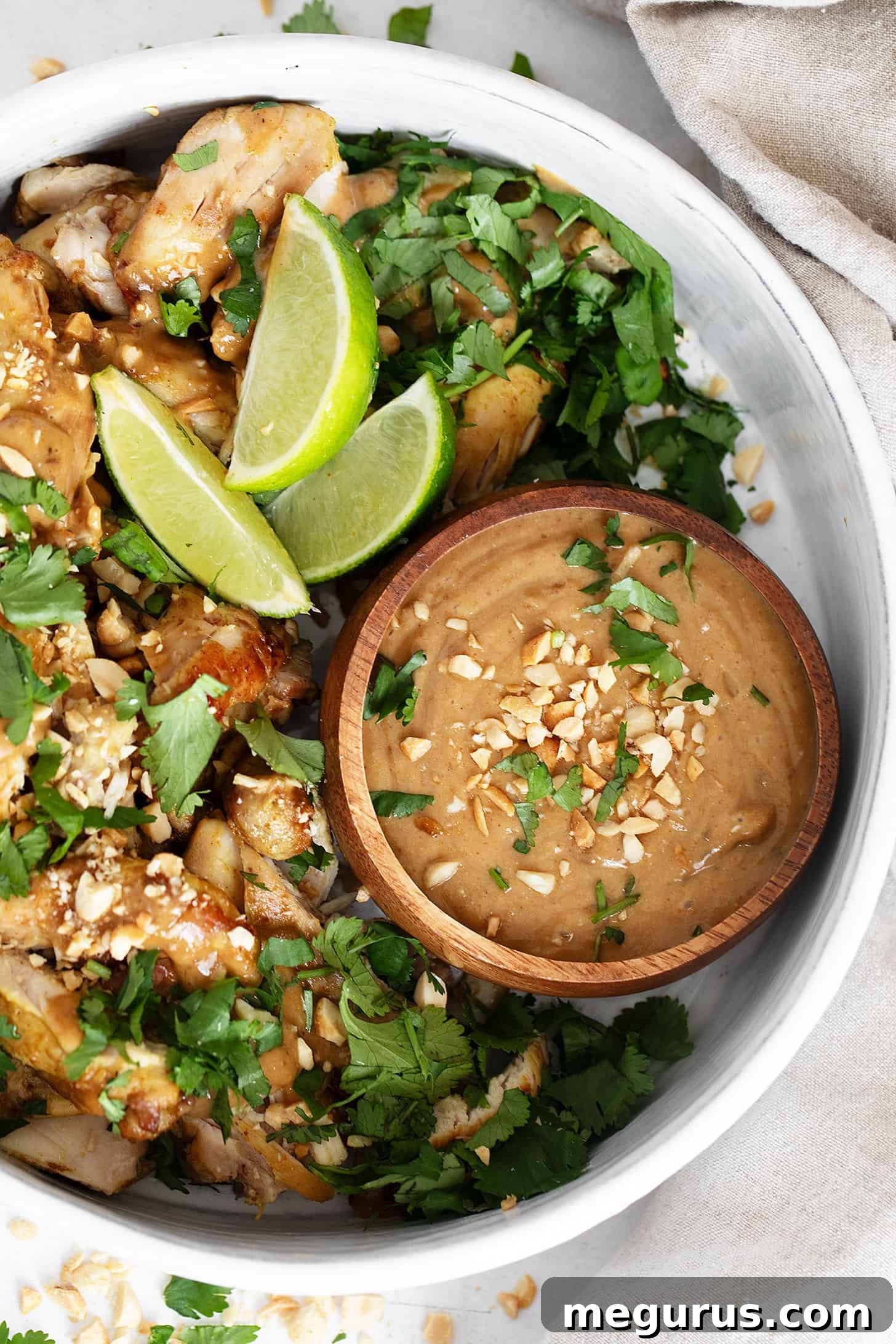 A close-up shot of the finished lime and coconut chicken with peanut sauce, garnished with cilantro.