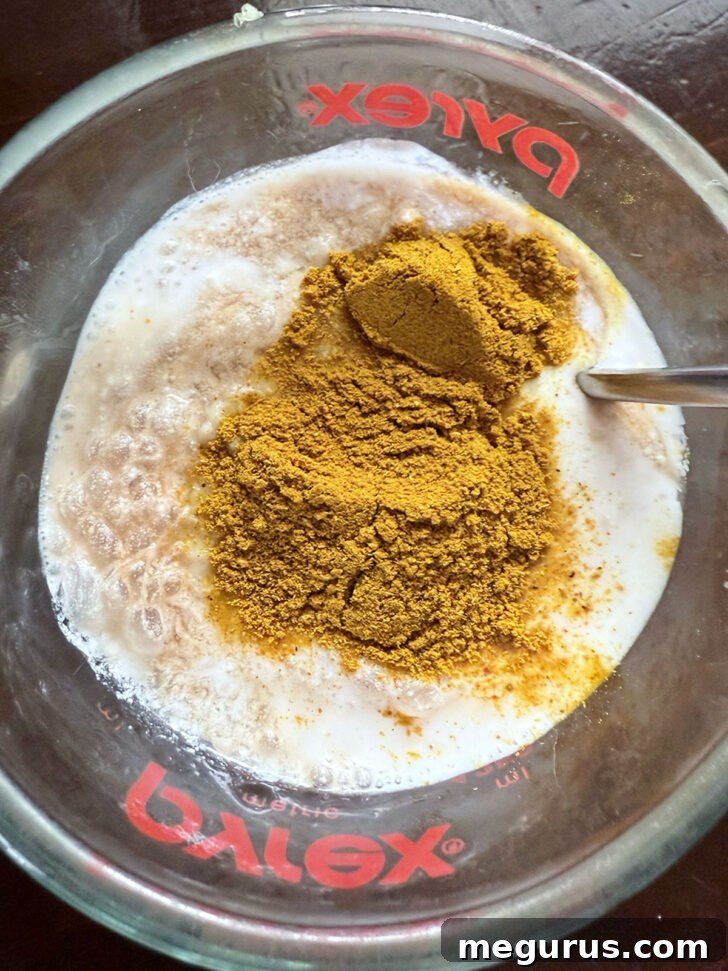 Coconut chicken marinade ingredients being combined in a measuring cup.