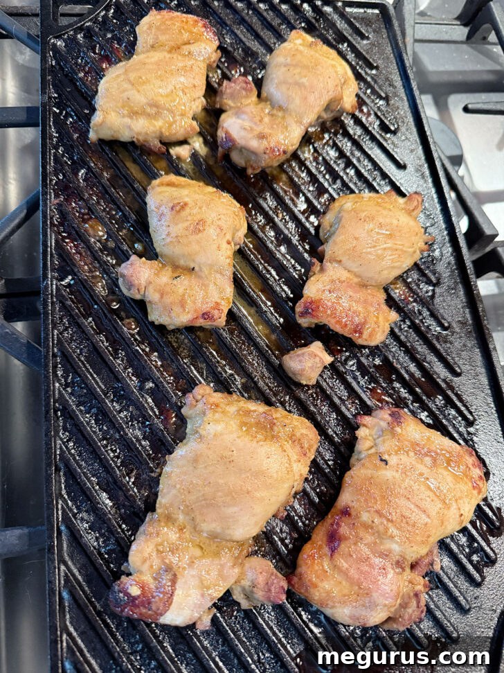 Oven-grilled coconut chicken thighs, perfectly charred and cooked through on a grill pan.