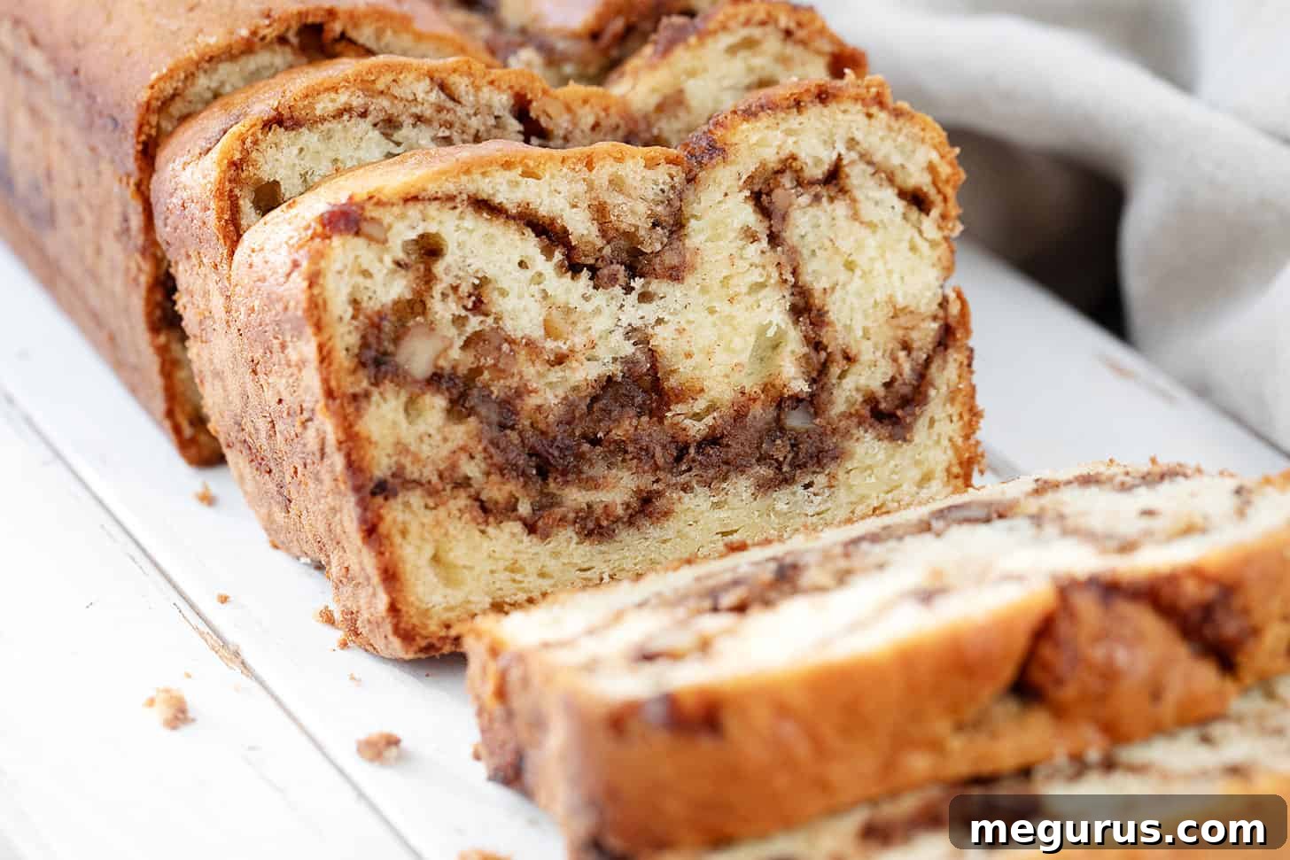 Sliced Hungarian coffee cake loaf on a wooden cutting board, showcasing its rich, swirled layers.