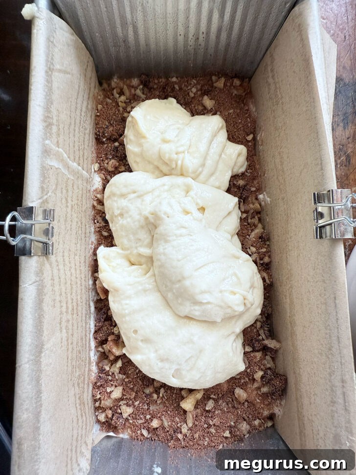 Adding a second layer of batter over the filling in the loaf pan.