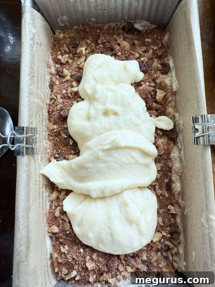 Adding the third layer of filling to the loaf pan.
