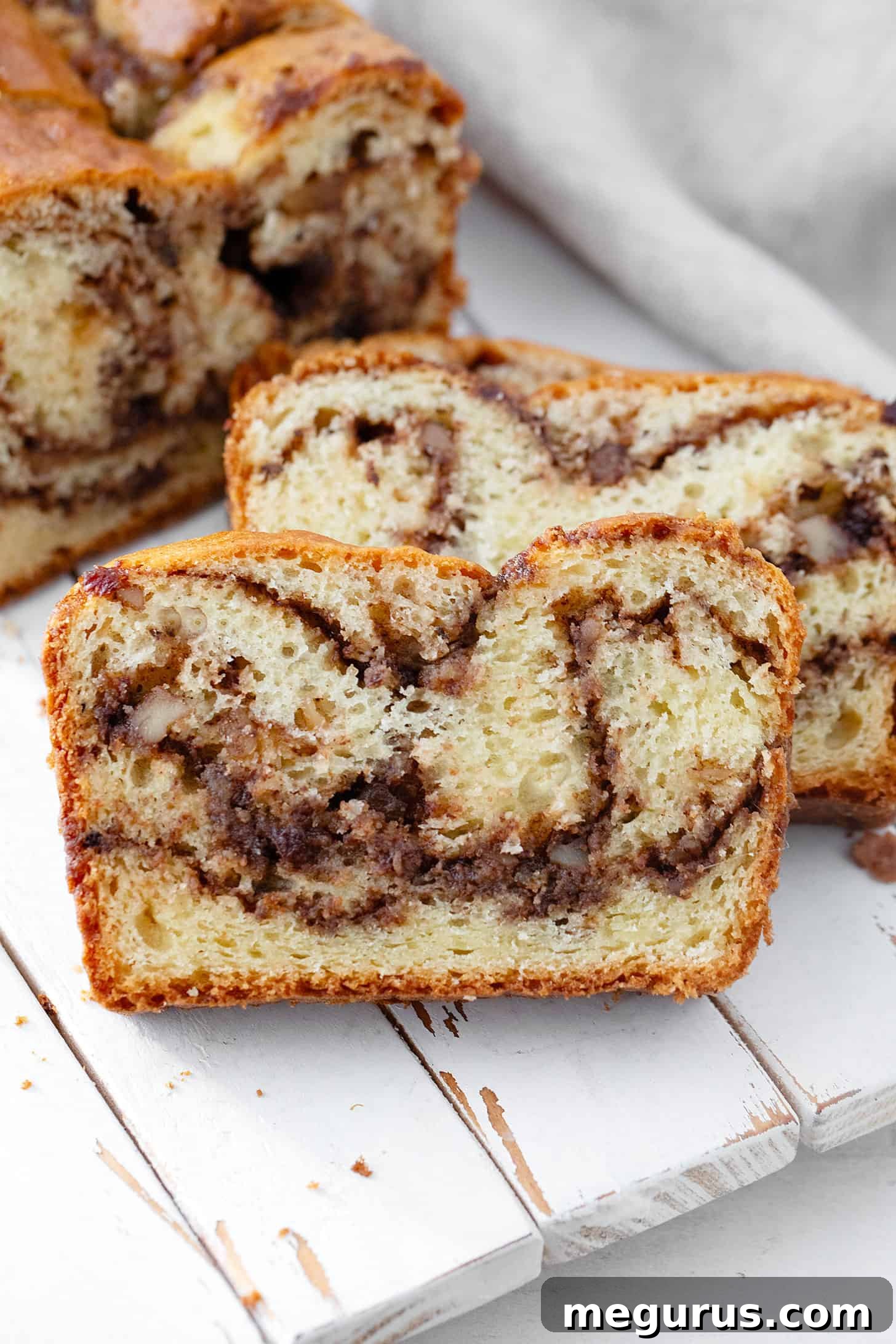A whole Hungarian coffee cake loaf resting on a cutting board, ready to be sliced and served.