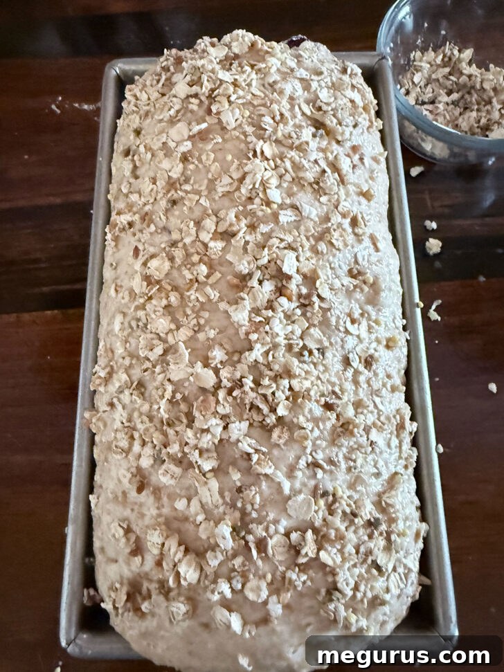 Quick oats and seeds pressed on top of the harvest grain bread before baking for a rustic crust.