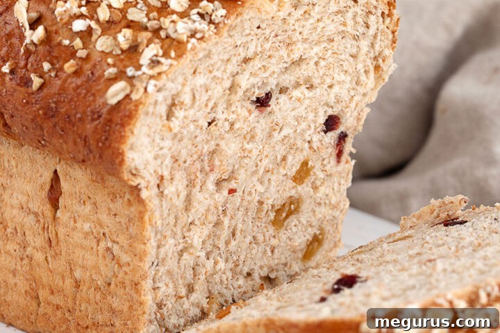 Harvest grain bread sliced on cutting board.