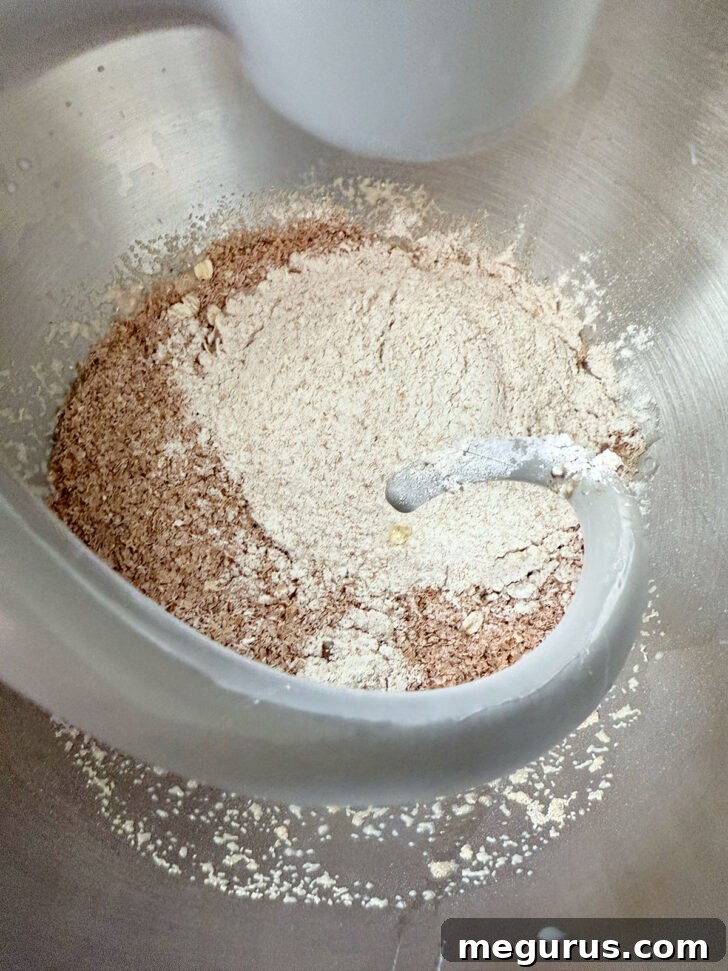 Grains and whole wheat flour in bowl of the stand mixer, ready for mixing.