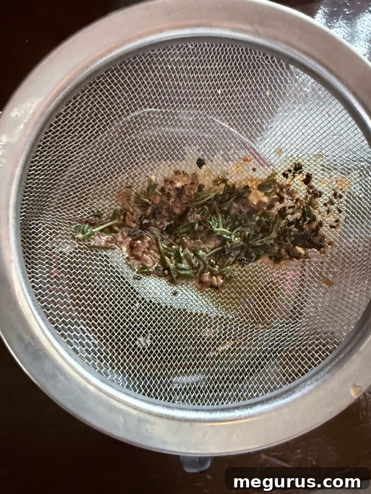 Straining the gravy in a sieve.